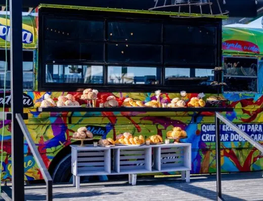 Colorido food truck mostrando una variedad de pasteles mexicanos al aire libre. Perfecto para marketing de la vibrante cultura de comida callejera.