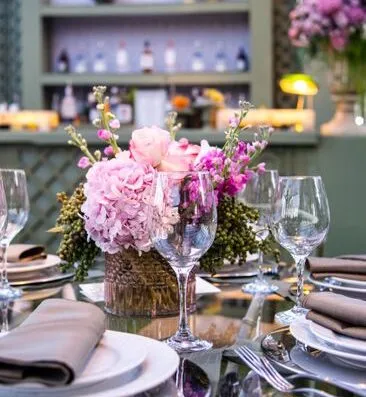 Decoración de mesa lujosa con centro de mesa floral y cristalería, perfecta para eventos sofisticados.