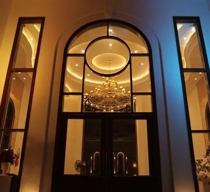 Elegante vestíbulo con un impresionante candelabro y arcos, creando un ambiente lujoso.