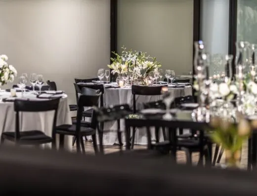 Decoración de mesa de boda lujosa con flores blancas y copas de vino en el interior.
