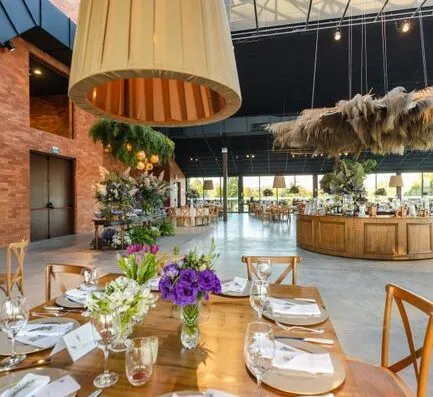 Una hermosa mesa de comedor rústica con elegante decoración floral, ideal para bodas o eventos.