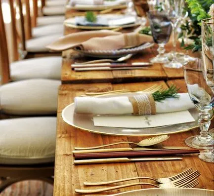 Close-up de una mesa bellamente decorada con flores y cubiertos, perfecta para bodas o cenas elegantes.
