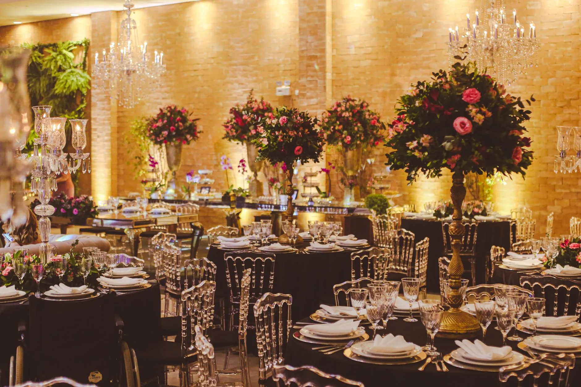 Configuración de evento interior lujosa con arreglos florales elegantes y candelabros de cristal.