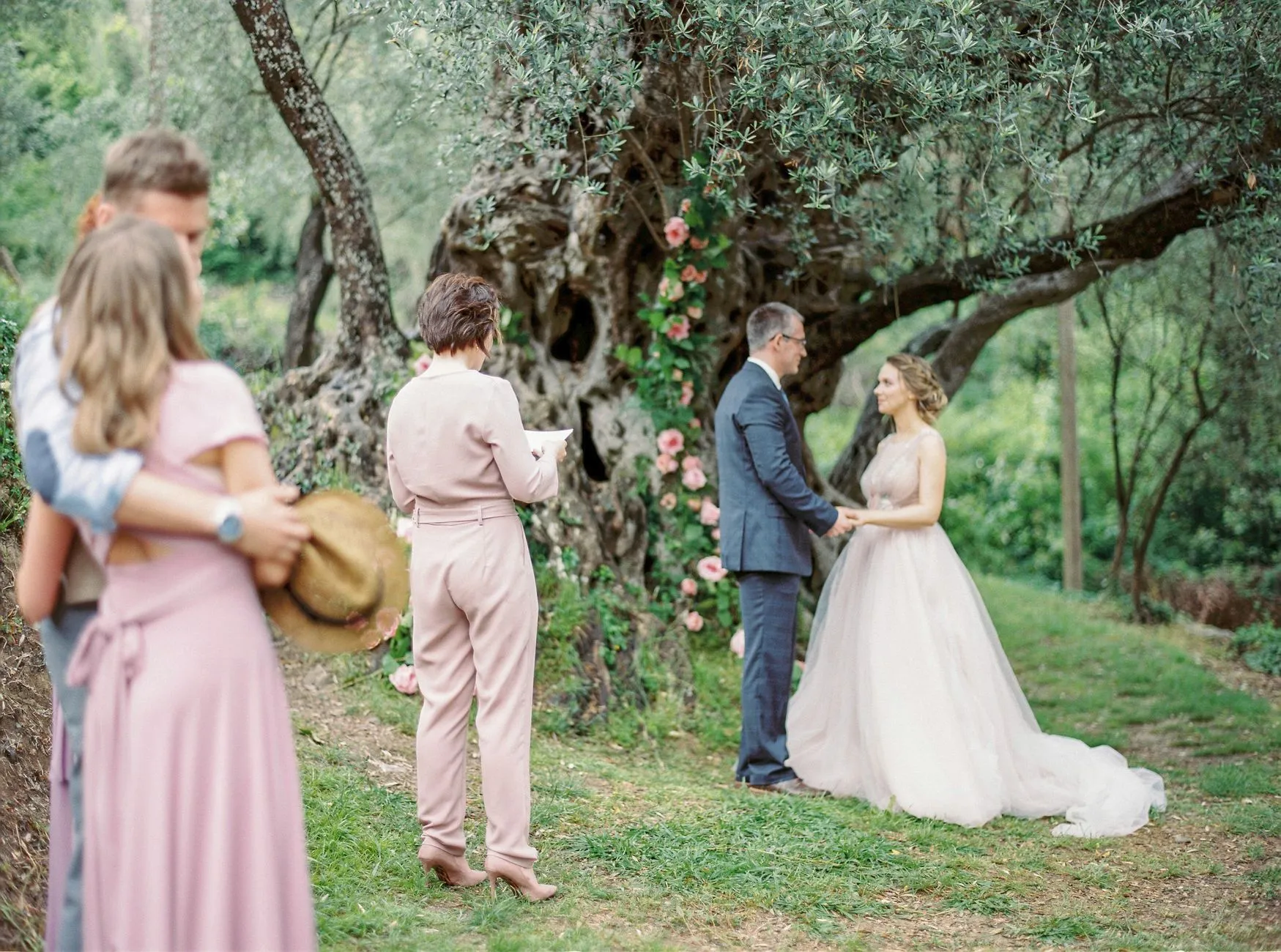 Ceremonia de boda romántica al aire libre con la novia y el novio bajo un árbol en flor (imagen de referencia)