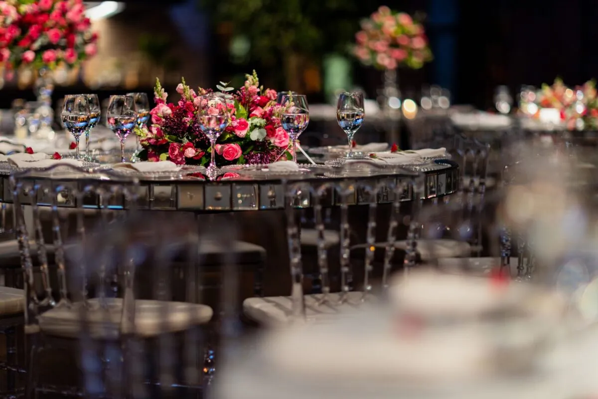 Montaje de mesa lujoso para recepción de boda con centro de mesa floral rosa y cristalería (imagen de referencia)