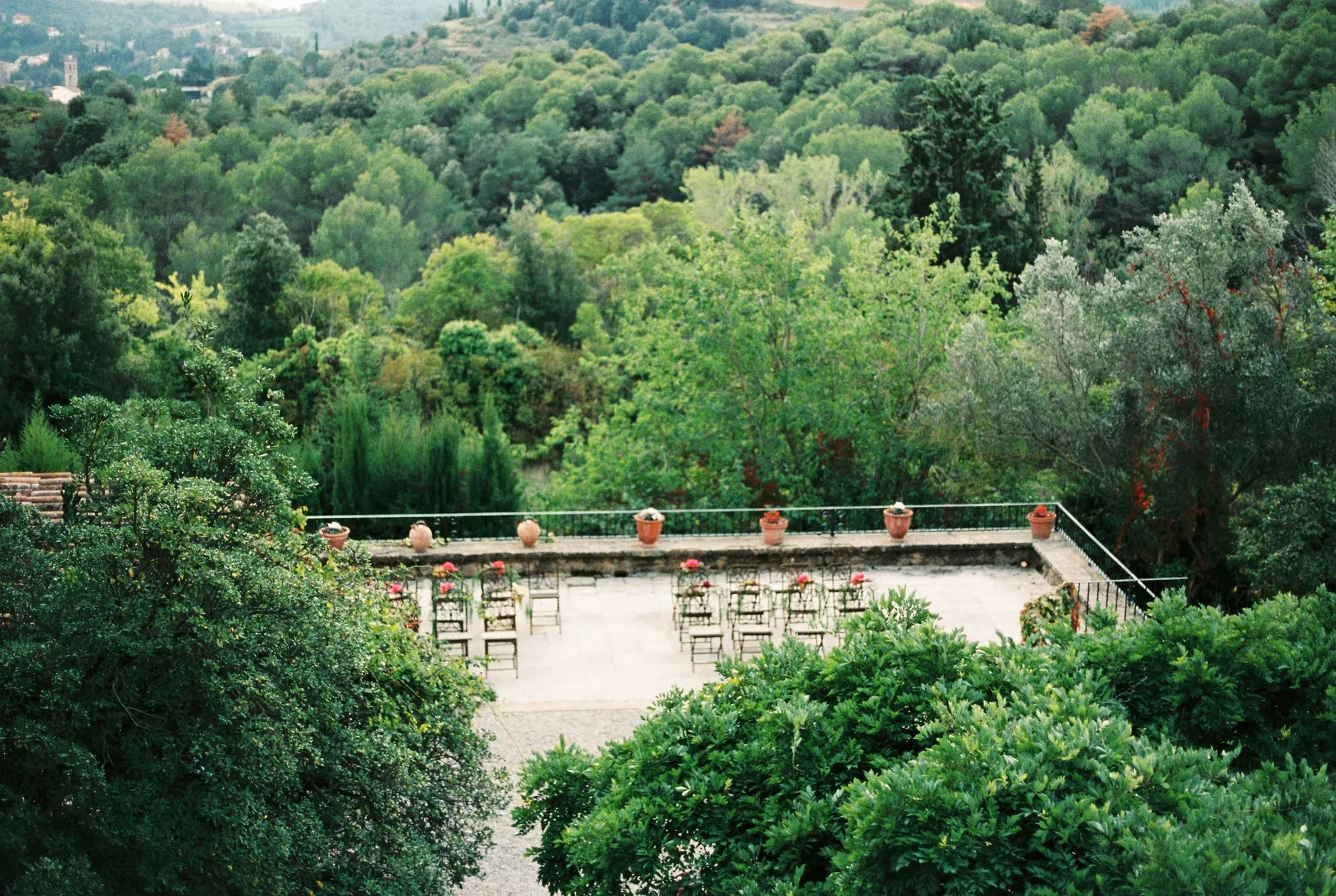 Terraza jardín con sillas rodeada de un frondoso y verde bosque, ideal para eventos al aire libre.
