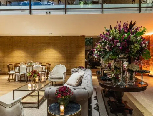 Elegante vestíbulo de hotel que presenta un exuberante arreglo floral y muebles estilizados en un ambiente sofisticado.
