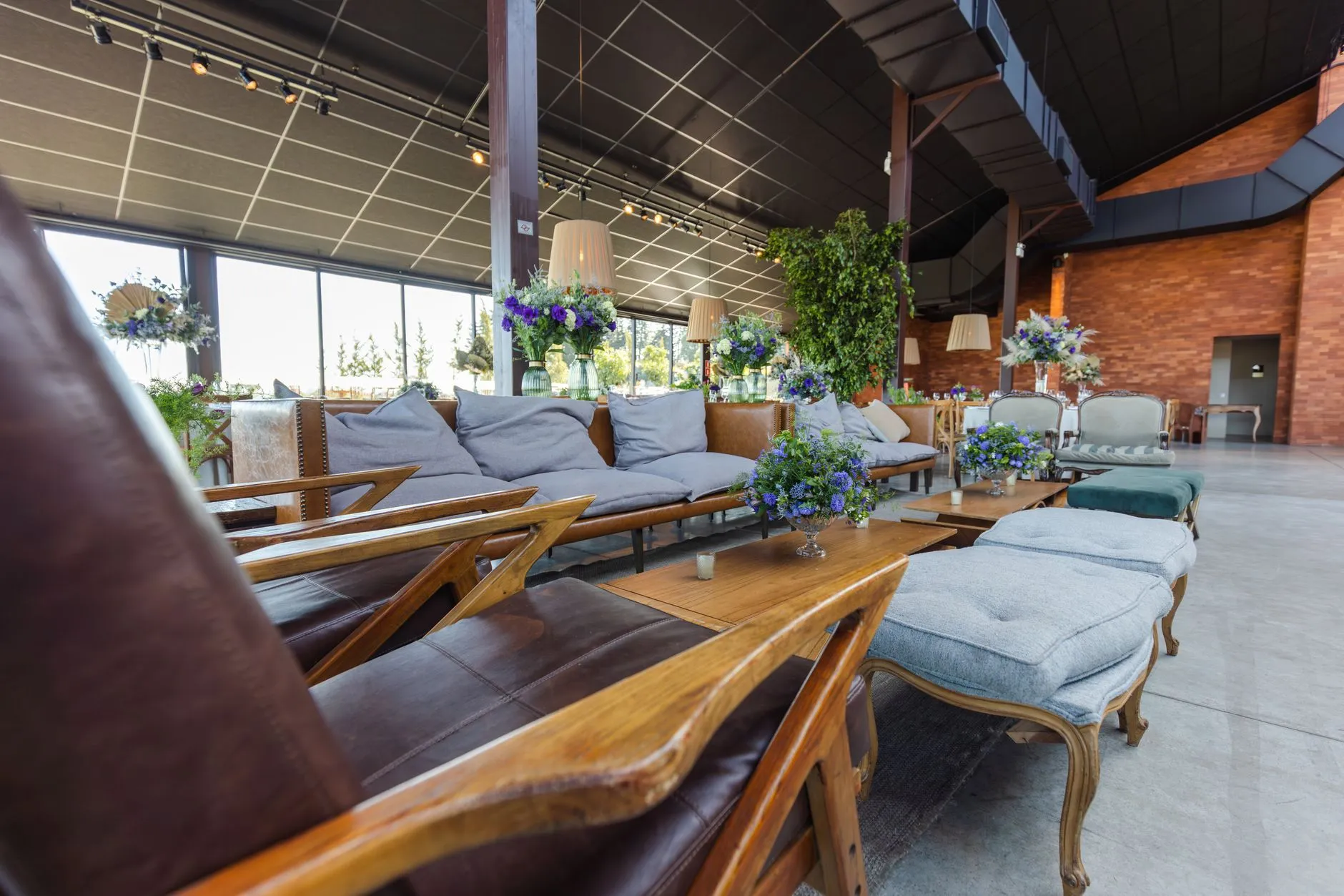 Amplio salón de banquetes con muebles modernos y exuberante decoración floral.