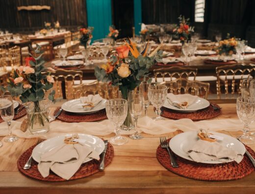 Una mesa de recepción de boda bellamente dispuesta con flores y vajilla elegante.