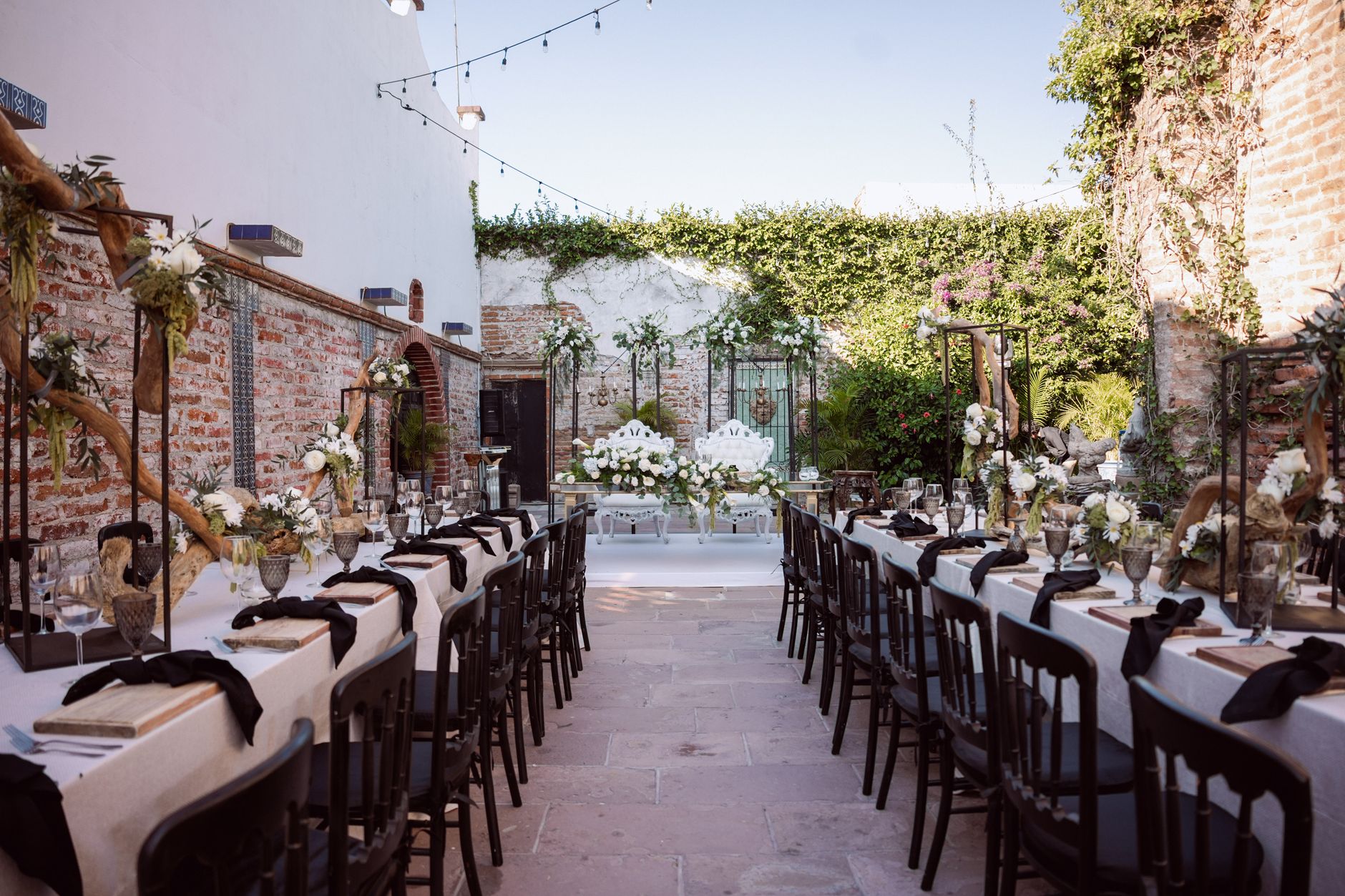 Mesa de boda al aire libre bellamente decorada con arreglos florales y encanto rústico.