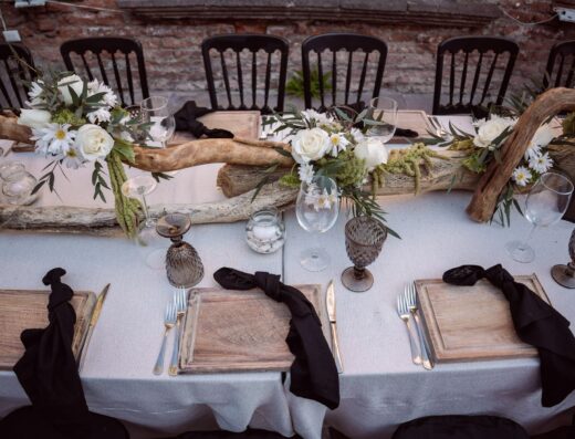 Mesa de boda rústica bellamente decorada con elementos florales y de madera.