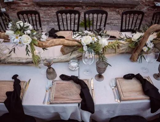 Mesa de boda rústica bellamente decorada con elementos florales y de madera.