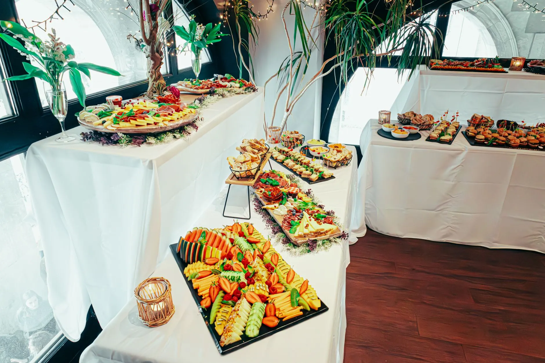 Elegante buffet interior con cocinas diversas, decoración vibrante y arreglos de plantas frescas.