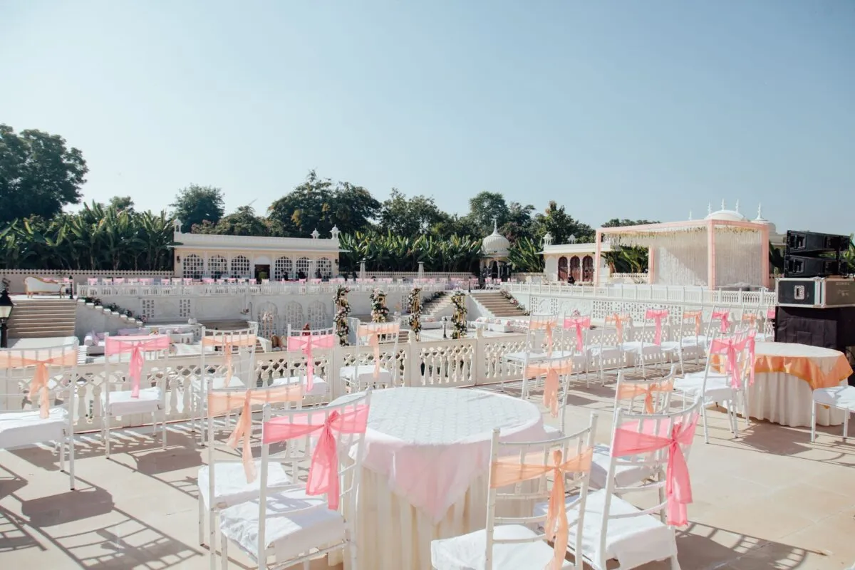 Elegante configuración de boda al aire libre con decoraciones y asientos en tonos pastel, perfecta para un evento en el jardín (imagen de referencia)