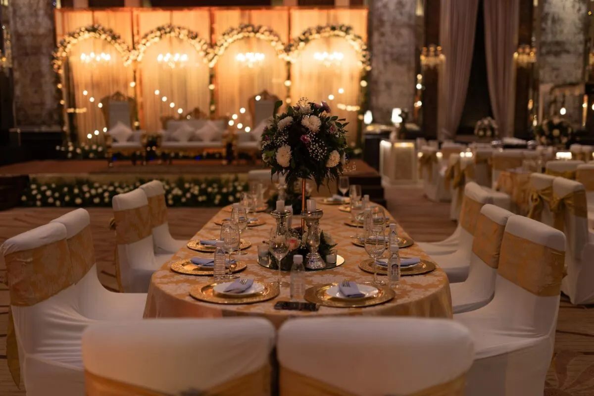 Un salón de recepción de boda bellamente decorado con arreglos florales y una iluminación elegante (imagen de referencia)