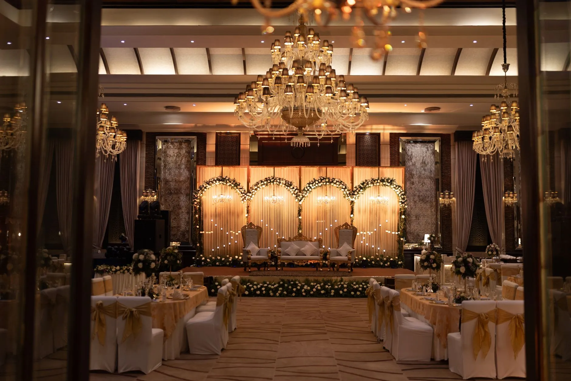 Lujoso salón de bodas decorado con candelabros y arreglos florales para una elegante celebración.