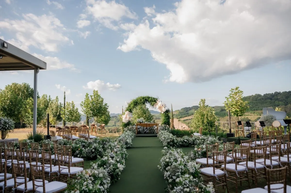 Hermoso lugar para bodas al aire libre con decoración floral y un paisaje pintoresco (imagen de referencia)