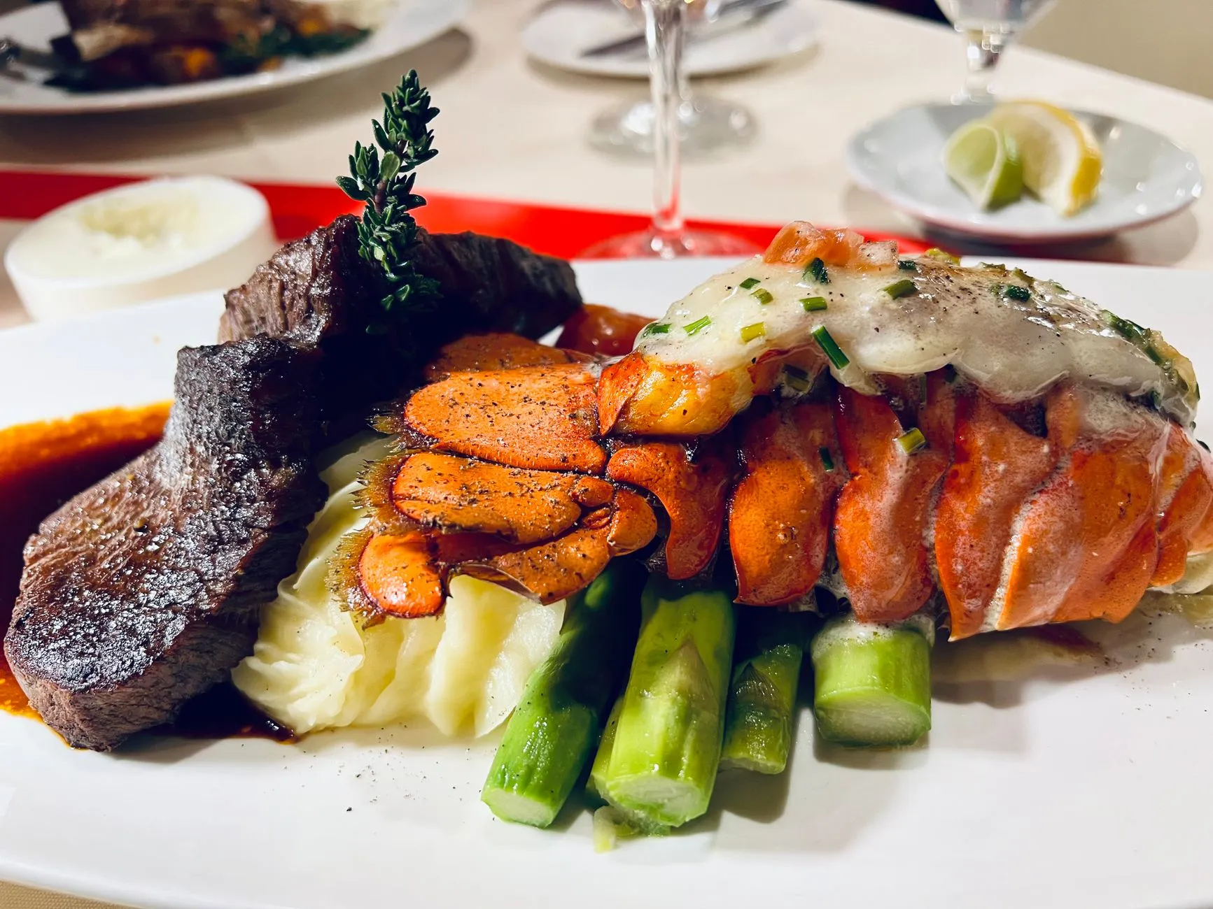 Disfrute de una lujosa comida de mar y tierra con cola de langosta, bistec y espárragos.