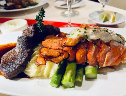 Disfrute de una lujosa comida de mar y tierra con cola de langosta, bistec y espárragos.