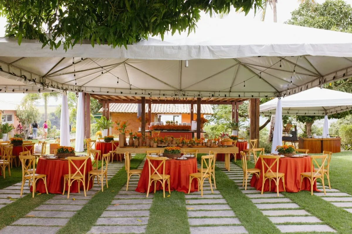Precioso montaje para una boda al aire libre con decoración en rojo y naranja bajo un dosel blanco (imagen de referencia)