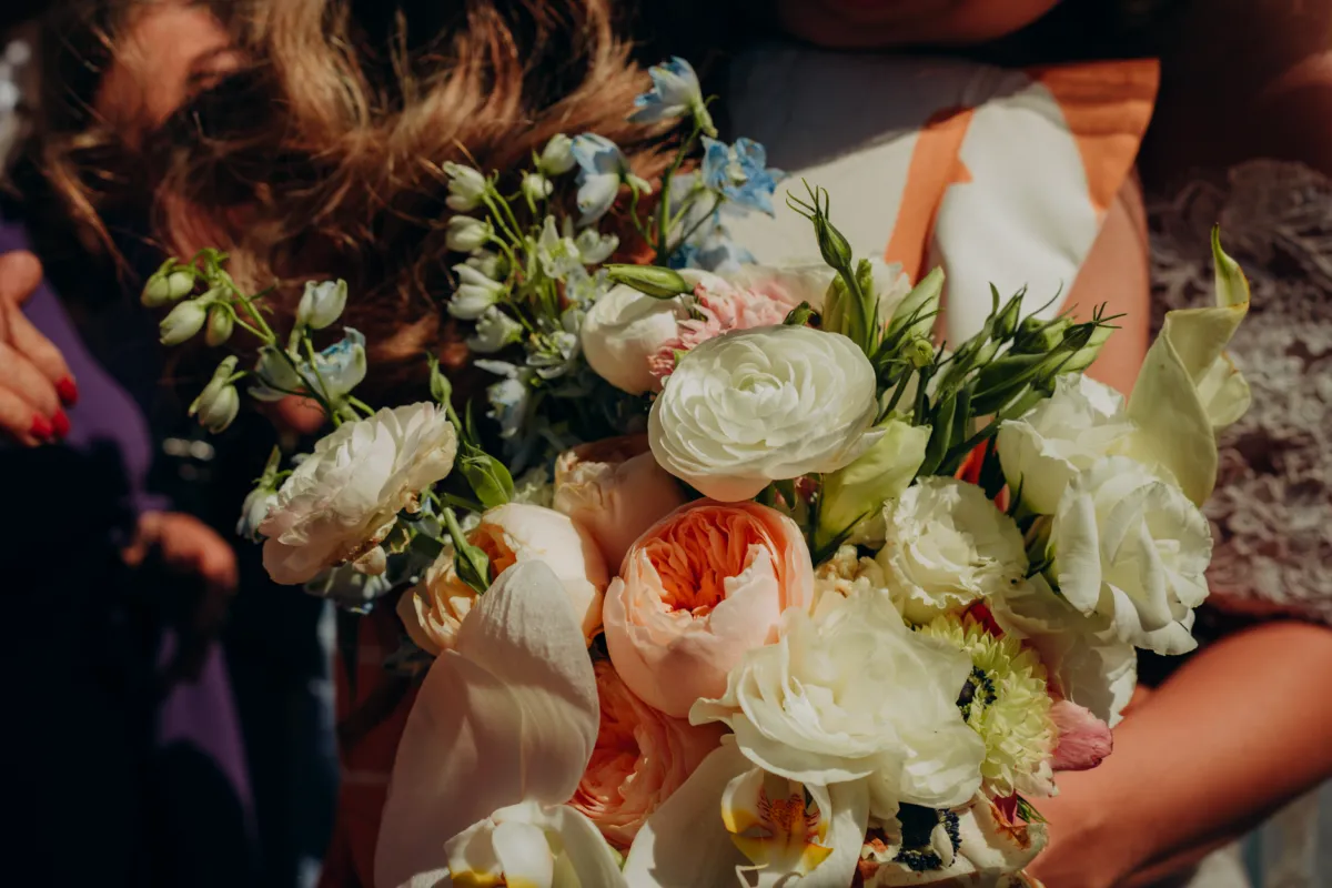 Primer plano de un ramo de novia con elegantes flores en un entorno soleado (imagen de referencia)
