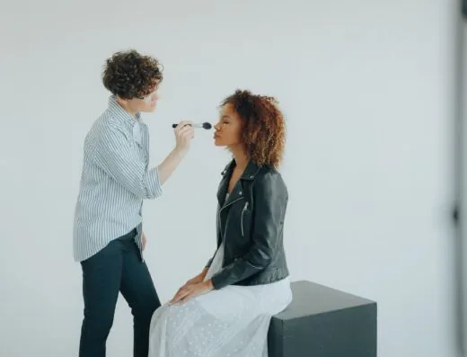 Una maquilladora aplica cosméticos a una mujer en un estudio.
