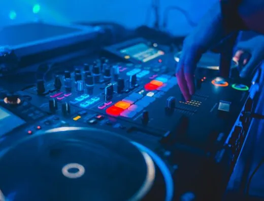 Toma vibrante de un mezclador de DJ en uso en una discoteca con luces coloridas