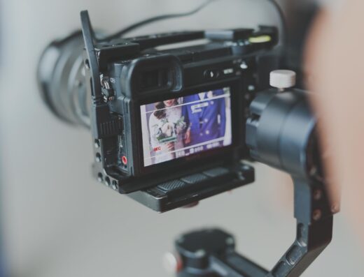 Primer plano de una cámara DSLR profesional grabando una escena. Perfecto para contextos de medios y tecnología.