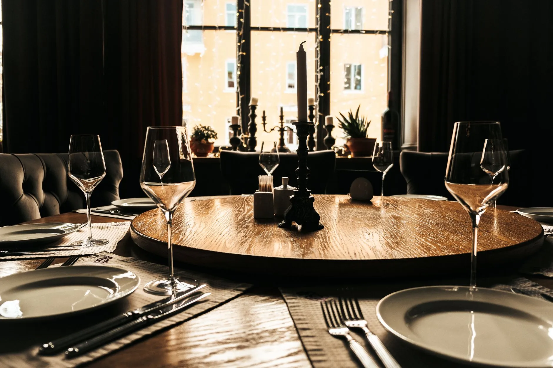 Una mesa de comedor bellamente puesta con una atmósfera iluminada por velas, perfecta para reuniones elegantes.