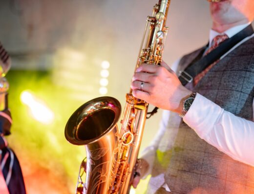 Un músico tocando el saxofón con pasión, mostrando talento bajo luces coloridas de escenario.
