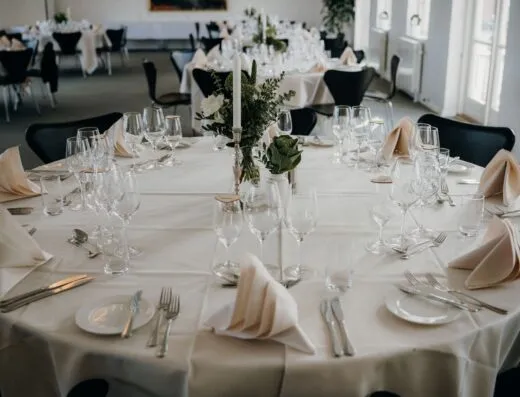 Una hermosa disposición de mesa para una recepción de bodas con vajilla elegante y un centro de mesa floral.