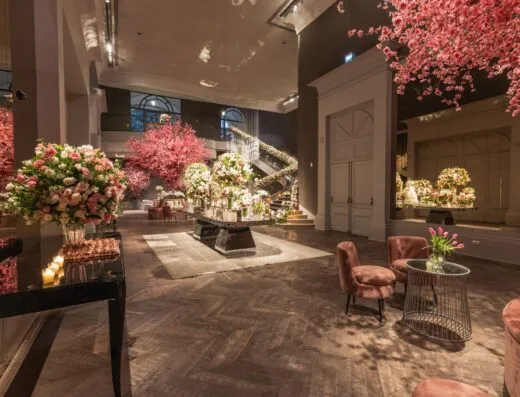 Espacio interior elegante con abundantes decoraciones florales y muebles lujosos, perfecto para eventos.