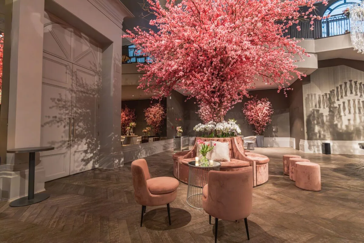 Lobby de hotel de lujo adornado con flores de cerezo rosas y un elegante arreglo de asientos (imagen de referencia)
