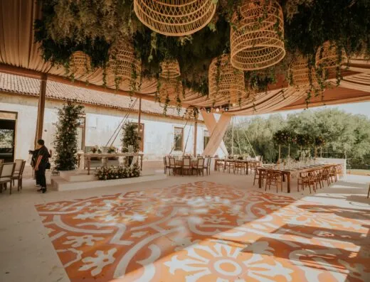 Atractivo lugar de boda al aire libre con elegantes decoraciones florales y disposición de asientos de madera.