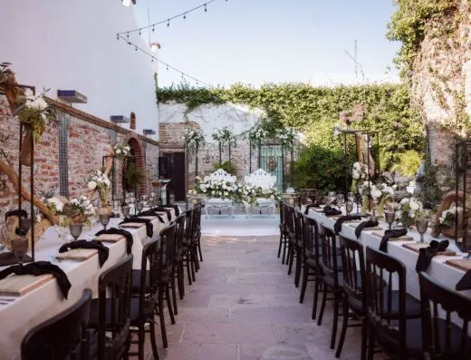 Mesa de boda al aire libre bellamente decorada con arreglos florales y encanto rústico.