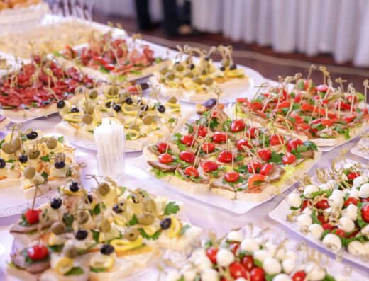 Exhibición vibrante de aperitivos variados y finger foods en un buffet de evento interior.