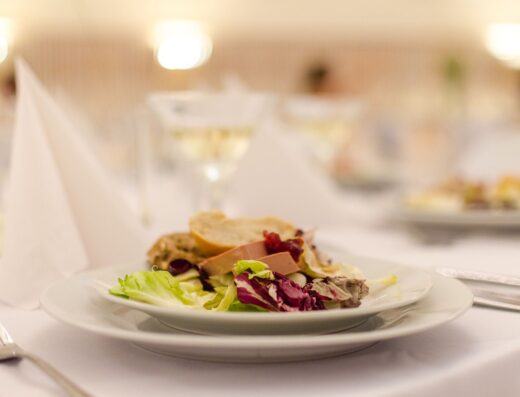 Plato de ensalada gourmet con pan en una mesa de restaurante elegantemente dispuesta, perfecta para experiencias de alta cocina.