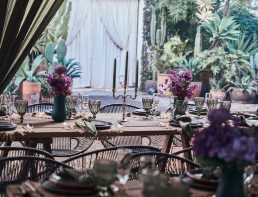 Escena cautivadora de comedor al aire libre con exuberante vegetación y elegantes arreglos florales en Morelia, México.