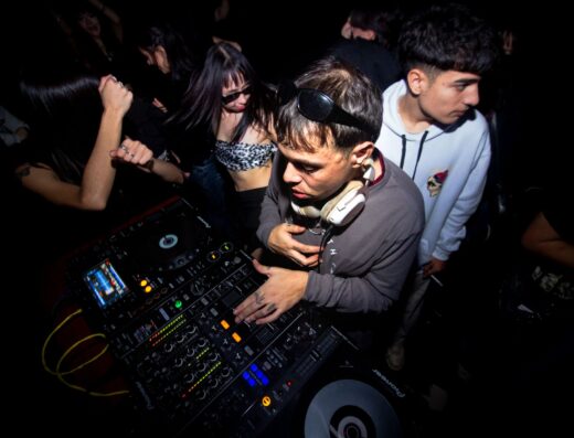 Un dinámico set de DJ con un público animado disfrutando de la música electrónica en una discoteca argentina.
