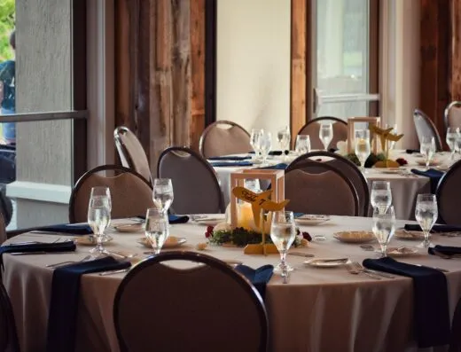 Una mesa de comedor bellamente dispuesta con elegantes copas y decoración en un moderno local interior.