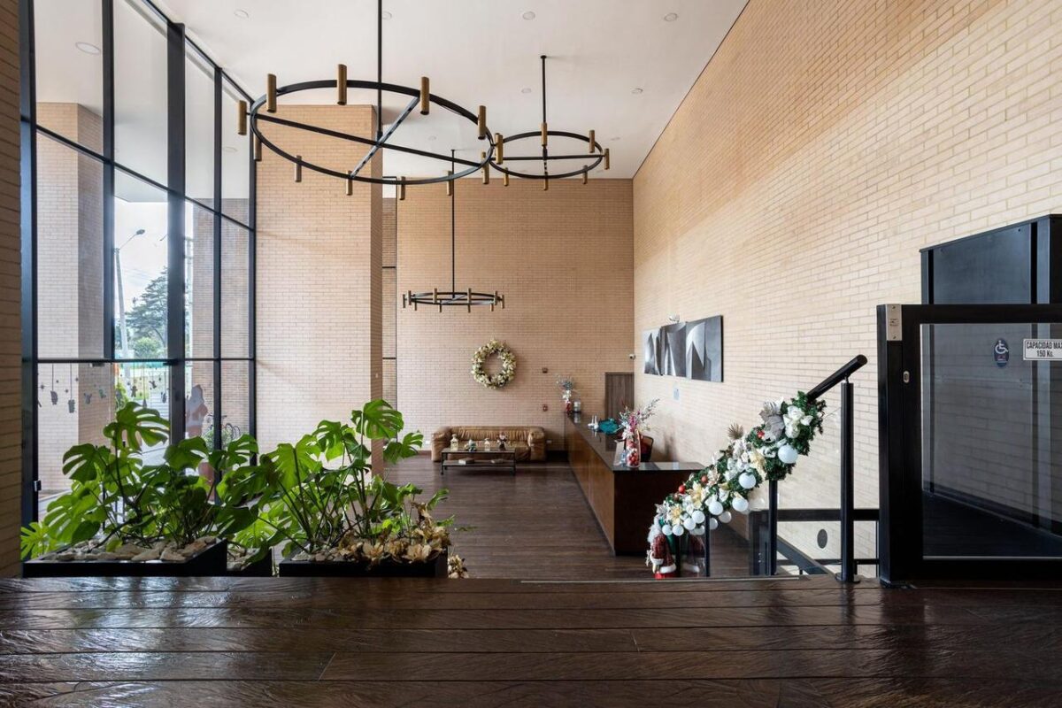 Amplio vestíbulo moderno en Bogotá con muebles elegantes, plantas y iluminación contemporánea (imagen de referencia)