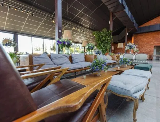 Amplio salón de banquetes con muebles modernos y exuberante decoración floral.