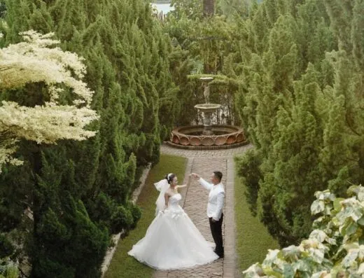 Pareja de boda elegante bailando en un jardín exuberante en Ciudad Ho Chi Minh.