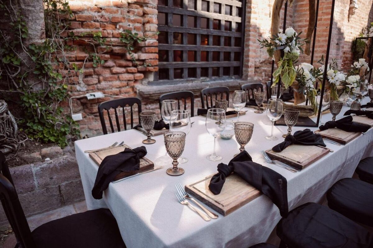 Mesa de boda al aire libre bellamente dispuesta con decoración floral y vajilla elegante, ideal para un evento sofisticado (imagen de referencia)