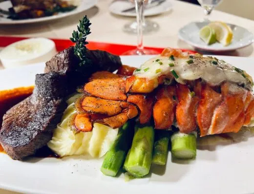 Disfrute de una lujosa comida de mar y tierra con cola de langosta, bistec y espárragos.