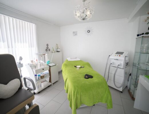 Sala de spa brillante y moderna con cama de masajes y equipo para tratamientos de bienestar.