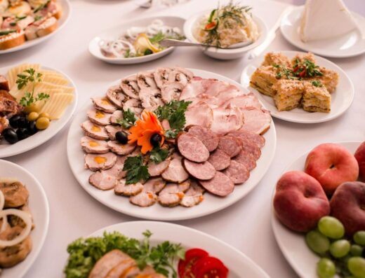 Una mesa bellamente dispuesta con una variedad de carnes, frutas y quesos.