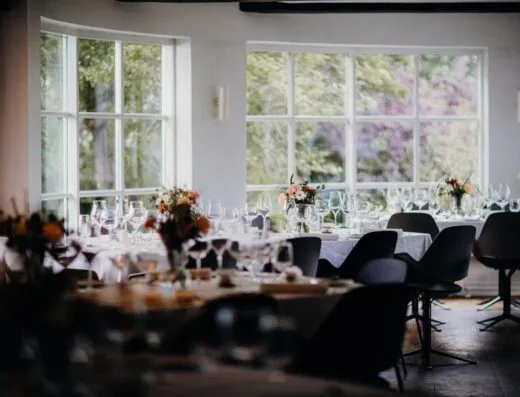 Comedor de restaurante sofisticado con una elegante decoración de mesa para un evento formal o recepción.