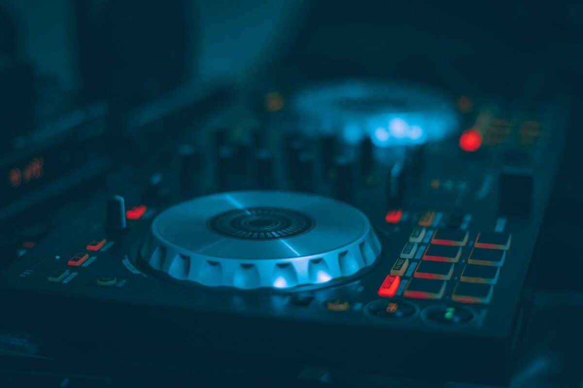 Una toma detallada de una mesa de mezclas de DJ con botones y controles iluminados, ideal para temas de música y tecnología (imagen de referencia)