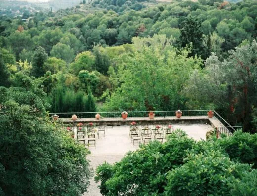 Terraza jardín con sillas rodeada de un frondoso y verde bosque, ideal para eventos al aire libre.